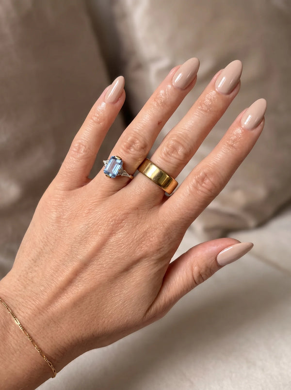 ALYN smart ring in gold worn on a manicured hand